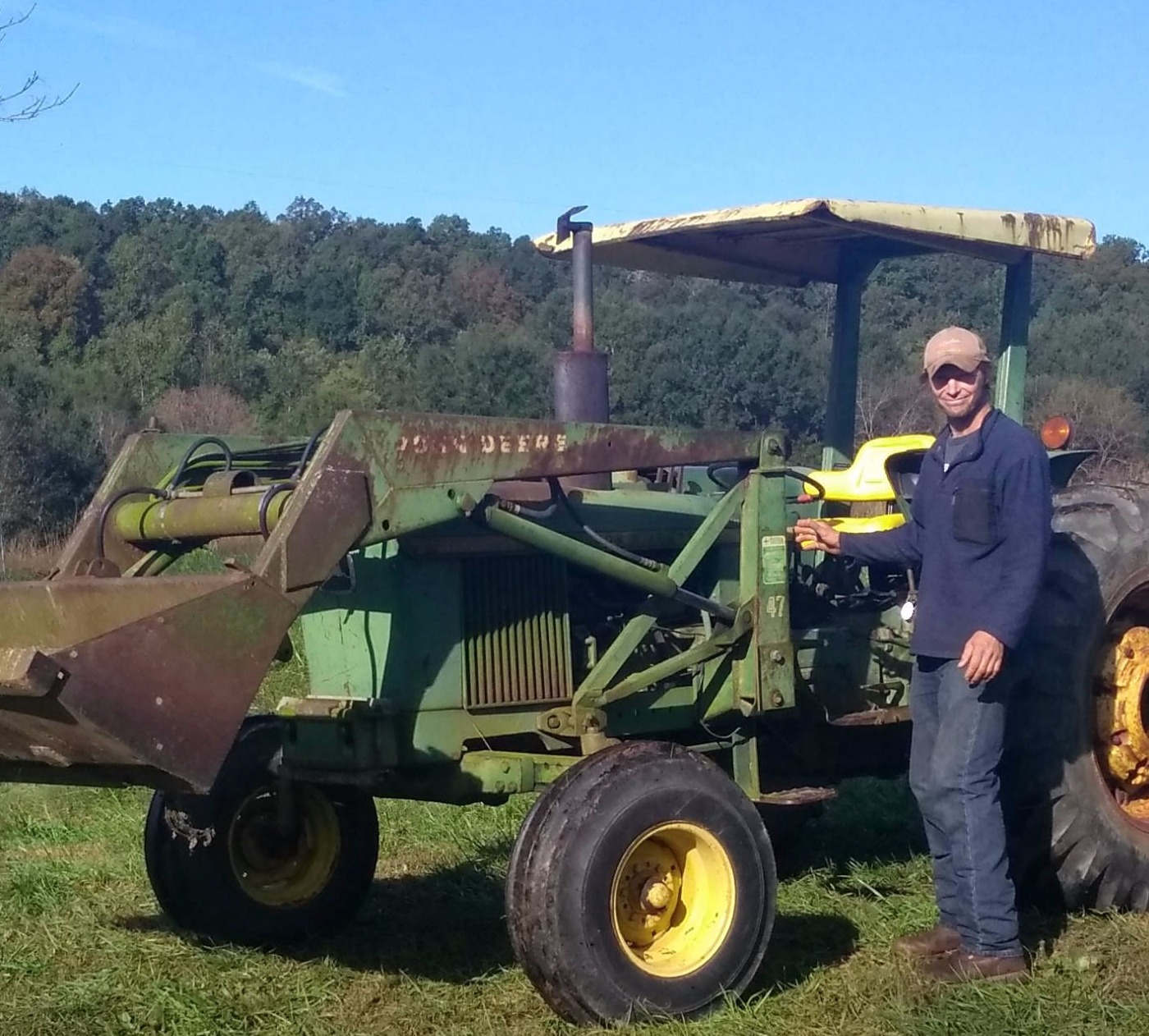 Older model tractor and Farmer Fred get the work done around the farm all year around